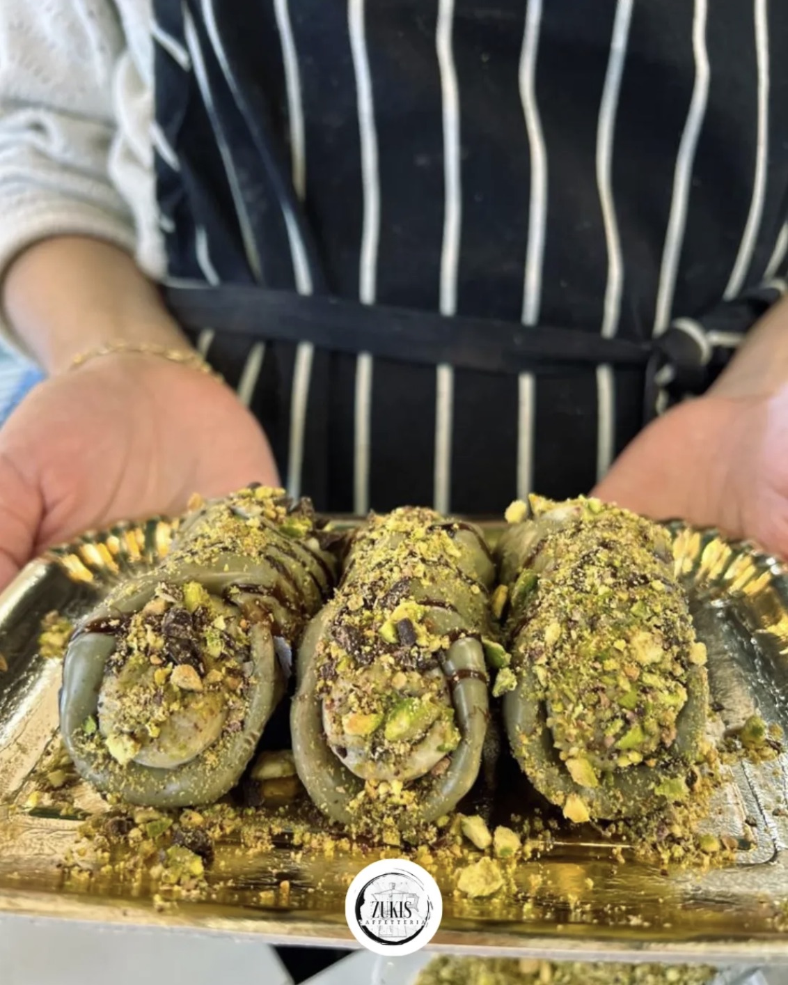 Freshly made pistachio pastries presented by hand